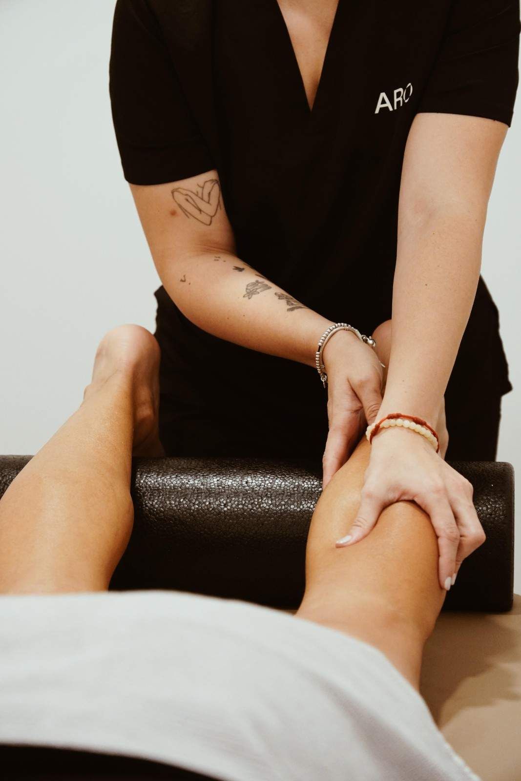 Masajista dando un masaje de piernas en un entorno de spa.