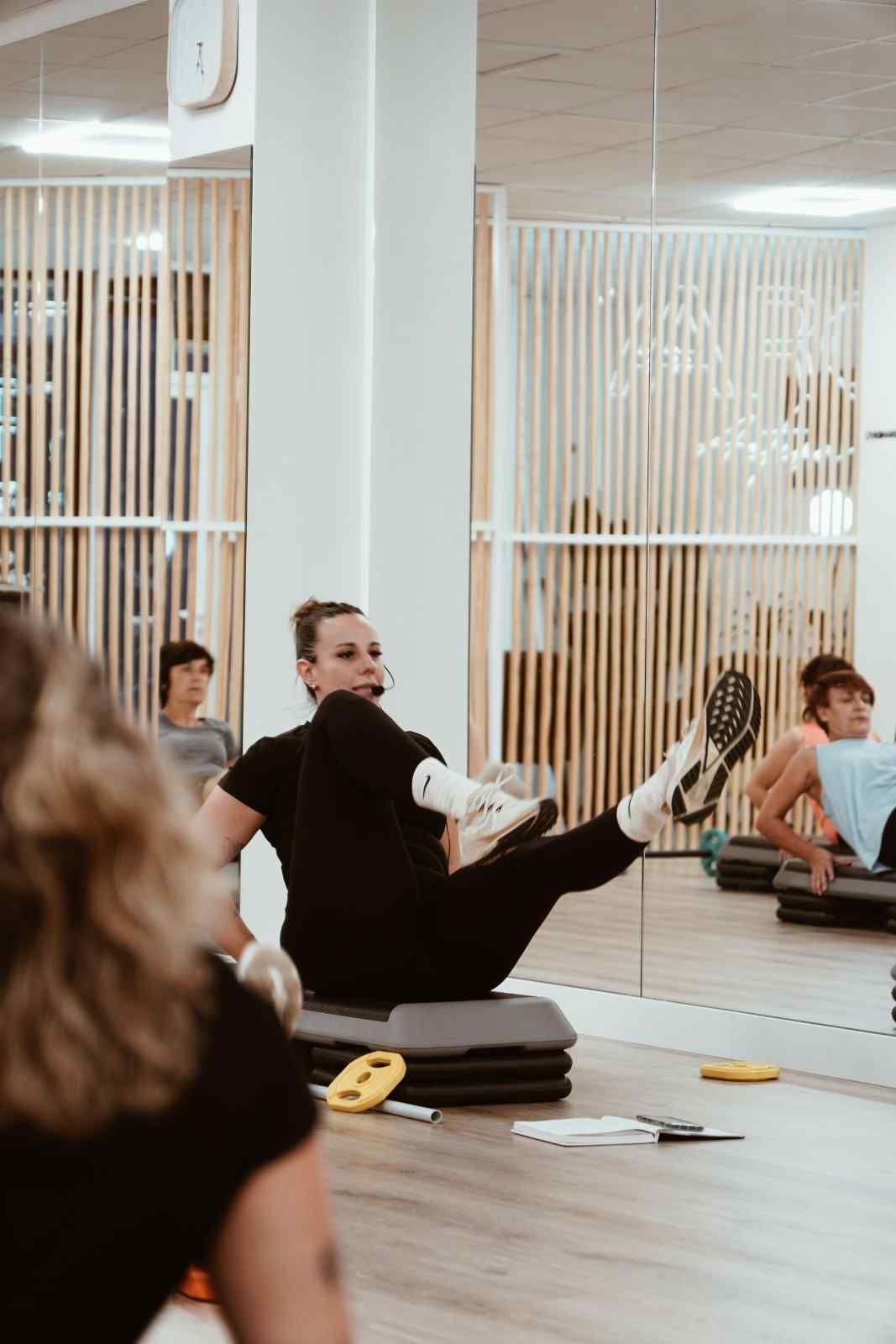 Personas estirándose sobre esterillas de yoga en un estudio con la palabra 