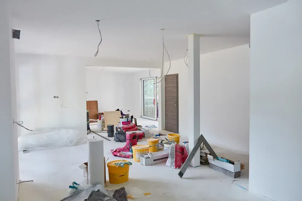 Una habitación grande con paredes blancas y muchas herramientas en el suelo.