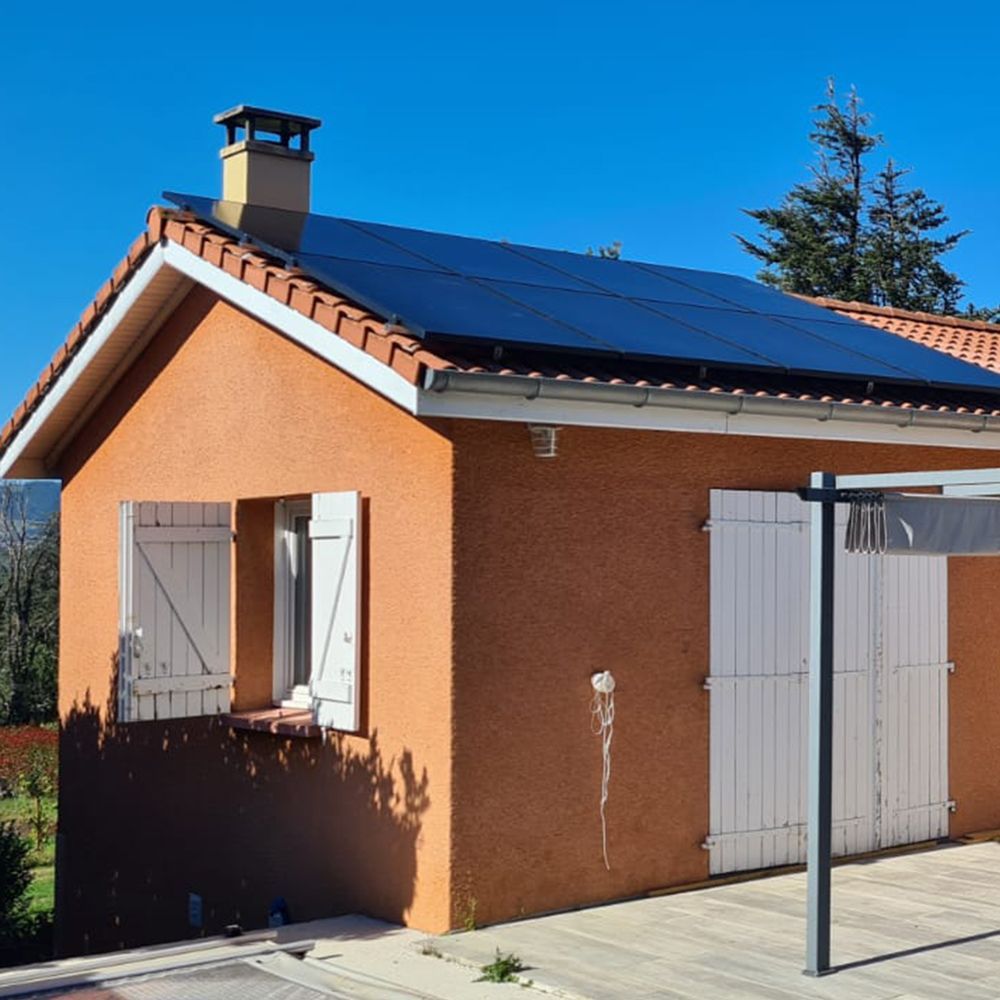 Panneaux photovoltaïques sur le toit d'une maison au mur orangé