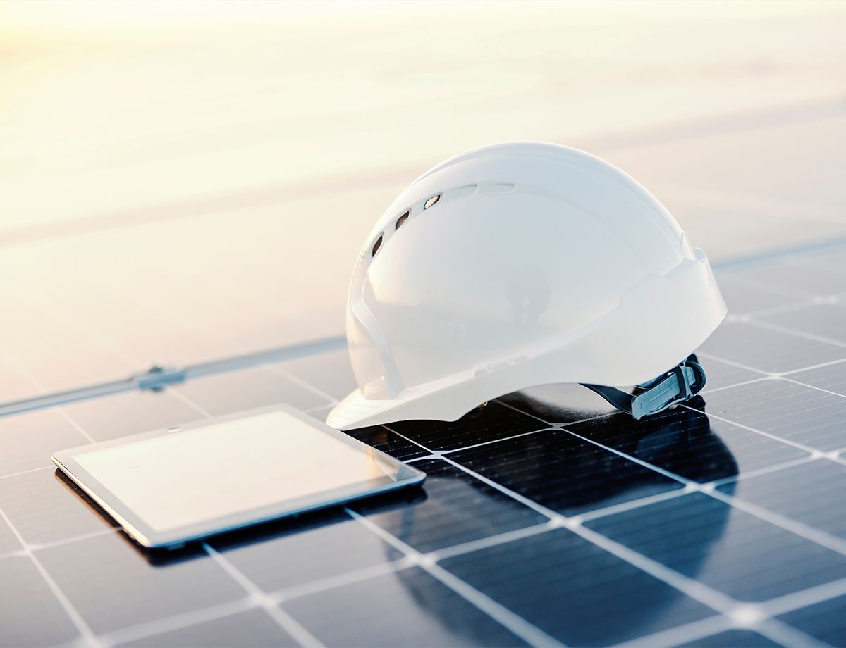 Casque de chantier et tablette posée sur un panneau solaire