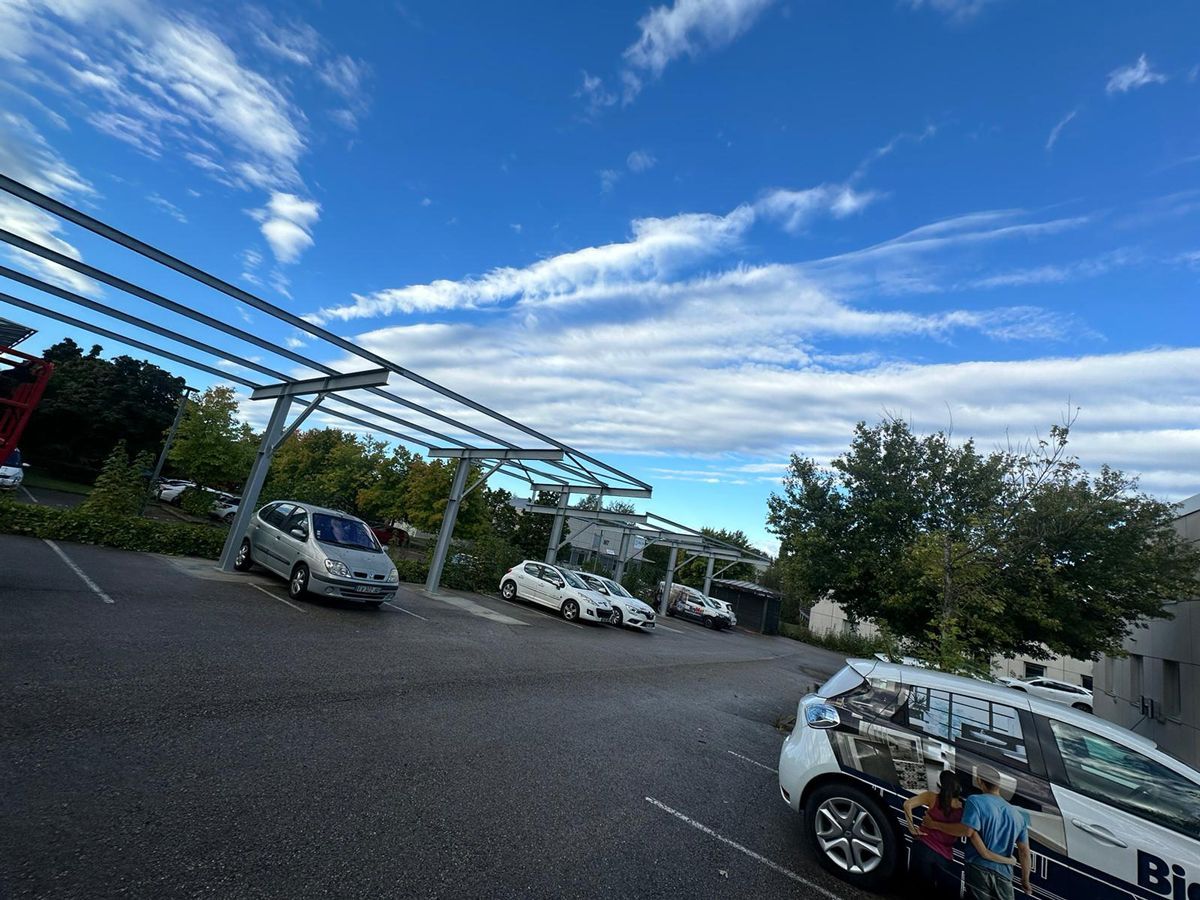 Installation de panneaux photovoltaïques au dessus d'un parking, vue sur le parking