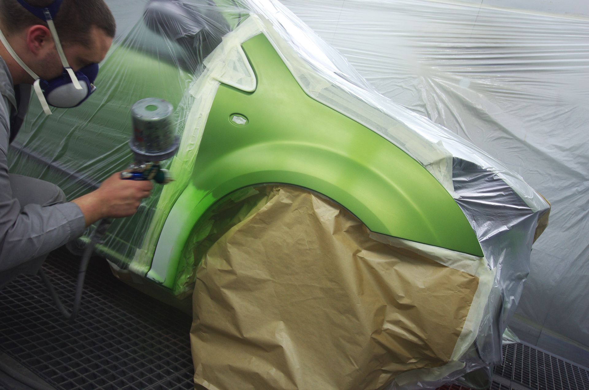 Peinture sur une carrosserie verte au pistolet.