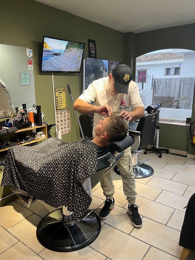 Un hombre se está cortando el pelo en una barbería.