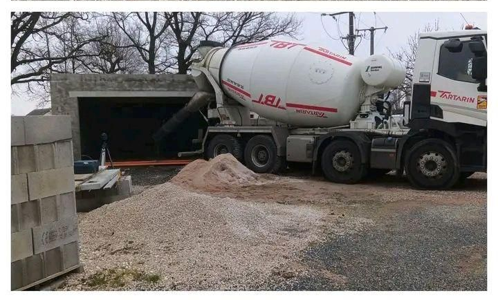 Camion-citerne déversant du béton dans les fouilles des fondations d'un sous-sol sur un chantier de construction