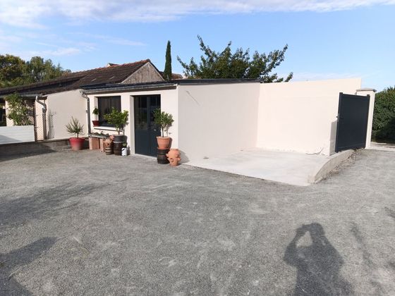 Façade d'un immeuble d'appartements rose avec de petites fenêtres et des palmes au premier plan