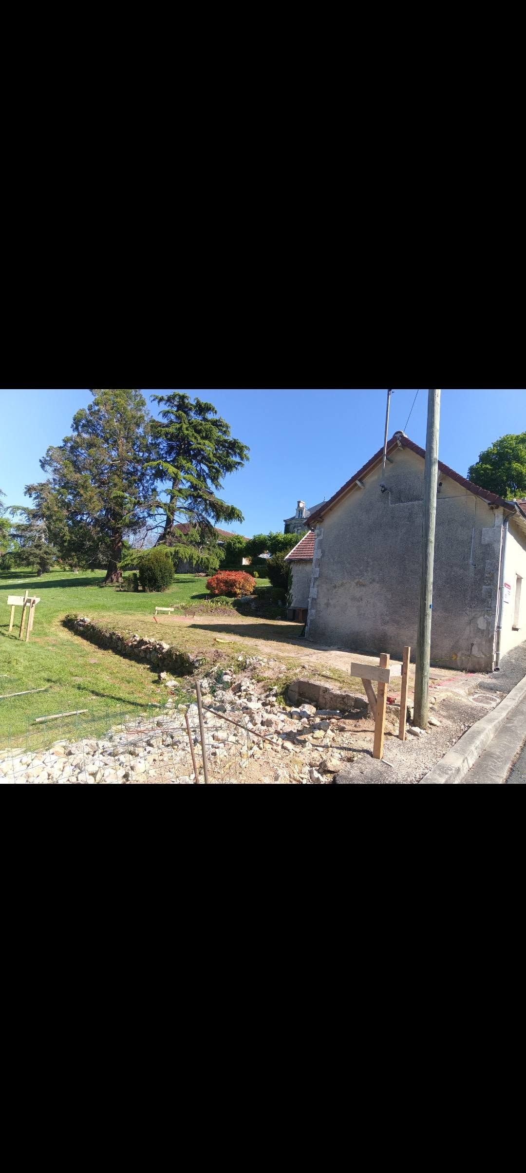 Main gantée alignant des croisillons de carrelage bleus et verts sur une surface en béton
