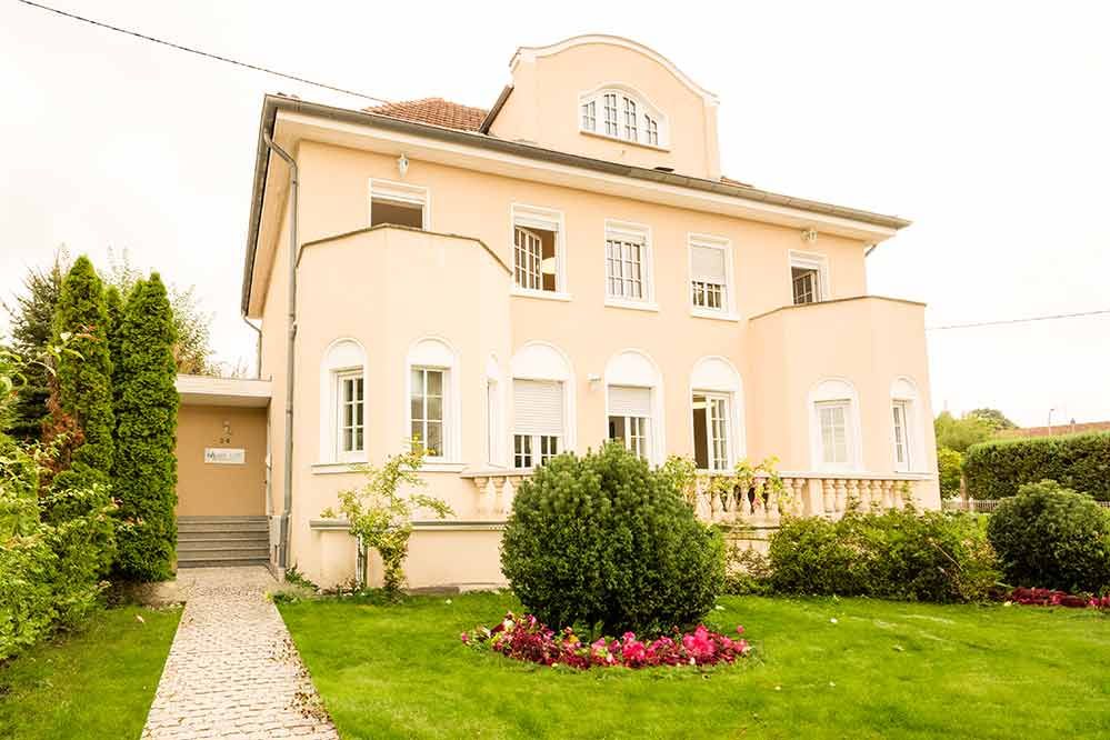 Ein großes Haus mit einem üppigen grünen Rasen davor.