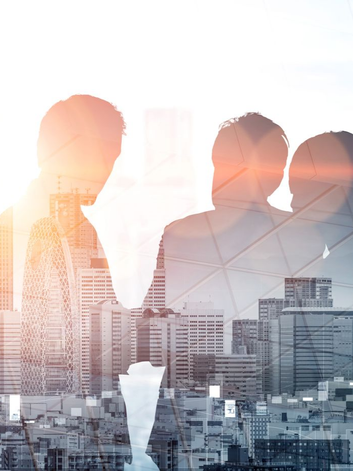 Des hommes d'affaires se serrant la main, avec en arrière-plan une silhouette urbaine.