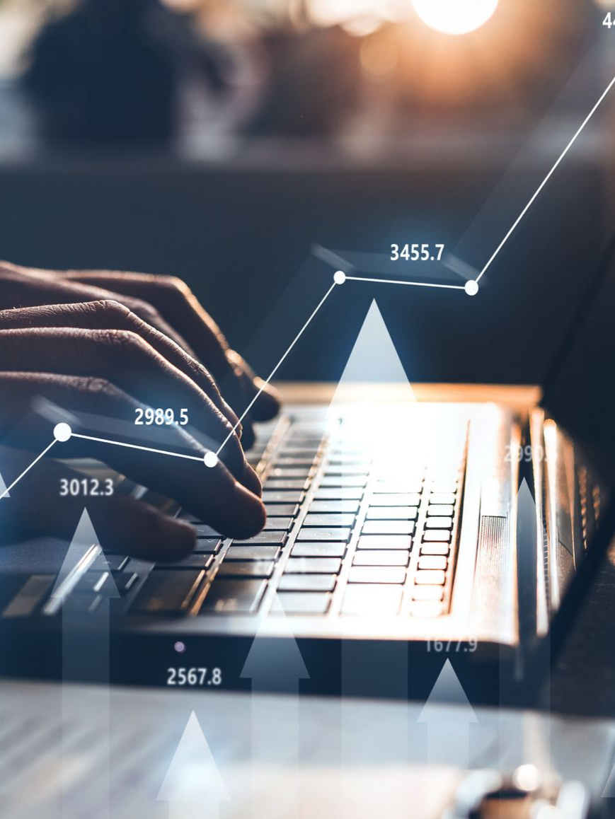 Des mains tapant sur un ordinateur portable avec un graphique.