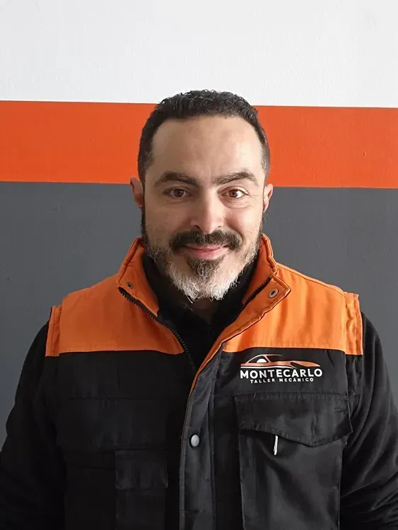 Un hombre con barba lleva una chaqueta negra y naranja.