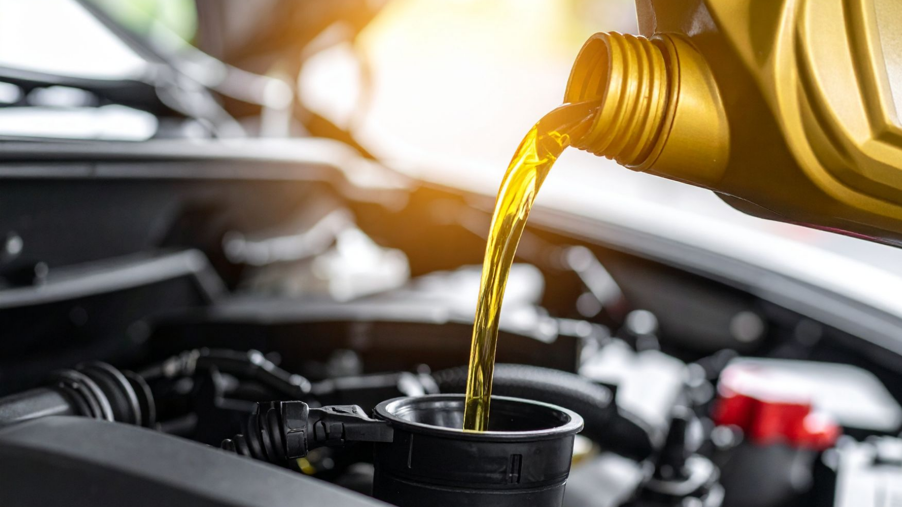 Verser de l'huile moteur neuve dans un moteur de voiture.