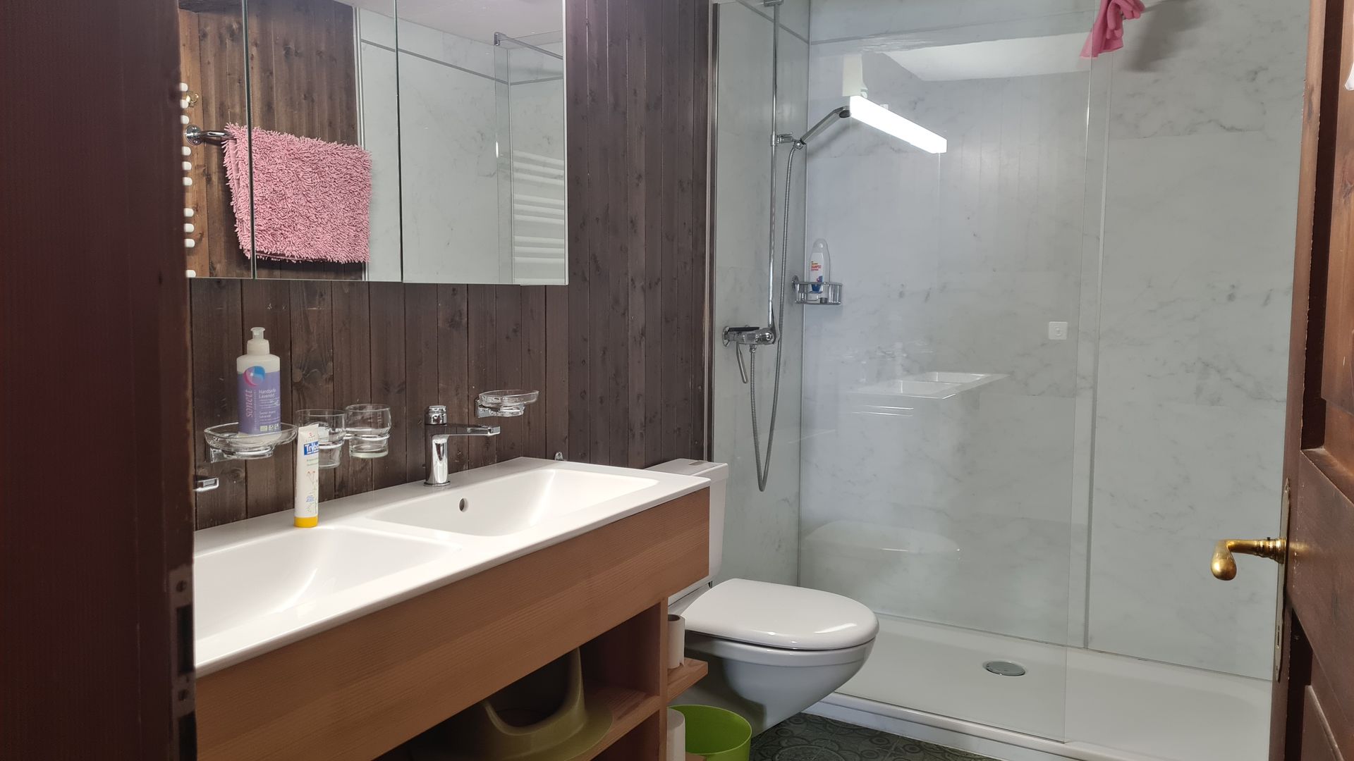 Ein Badezimmer mit zwei Lavabos, WC und Dusche mit Glaswand
