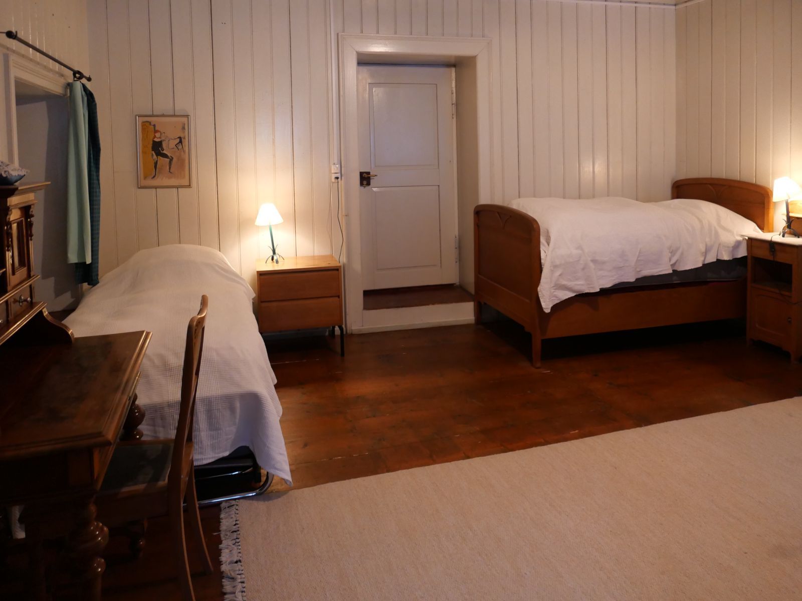 Ein Schlafzimmer mit weissem Wandtäfer und zwei altmodischen Bettstatten