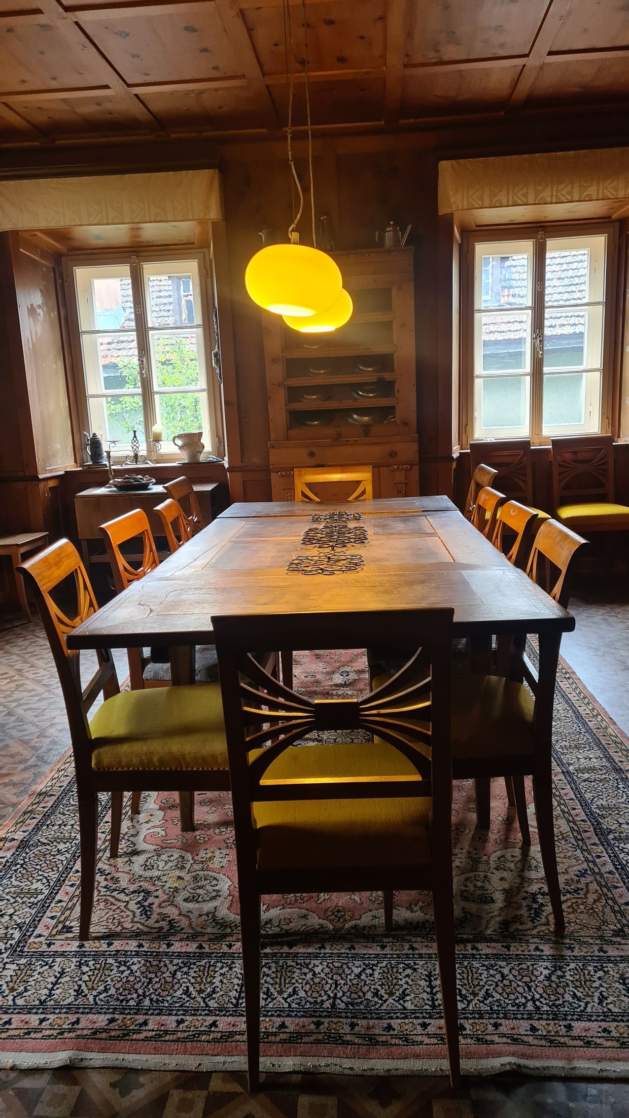Ein vornehmes Esszimmer mit Täferwänden und Biedermeierstühlen.