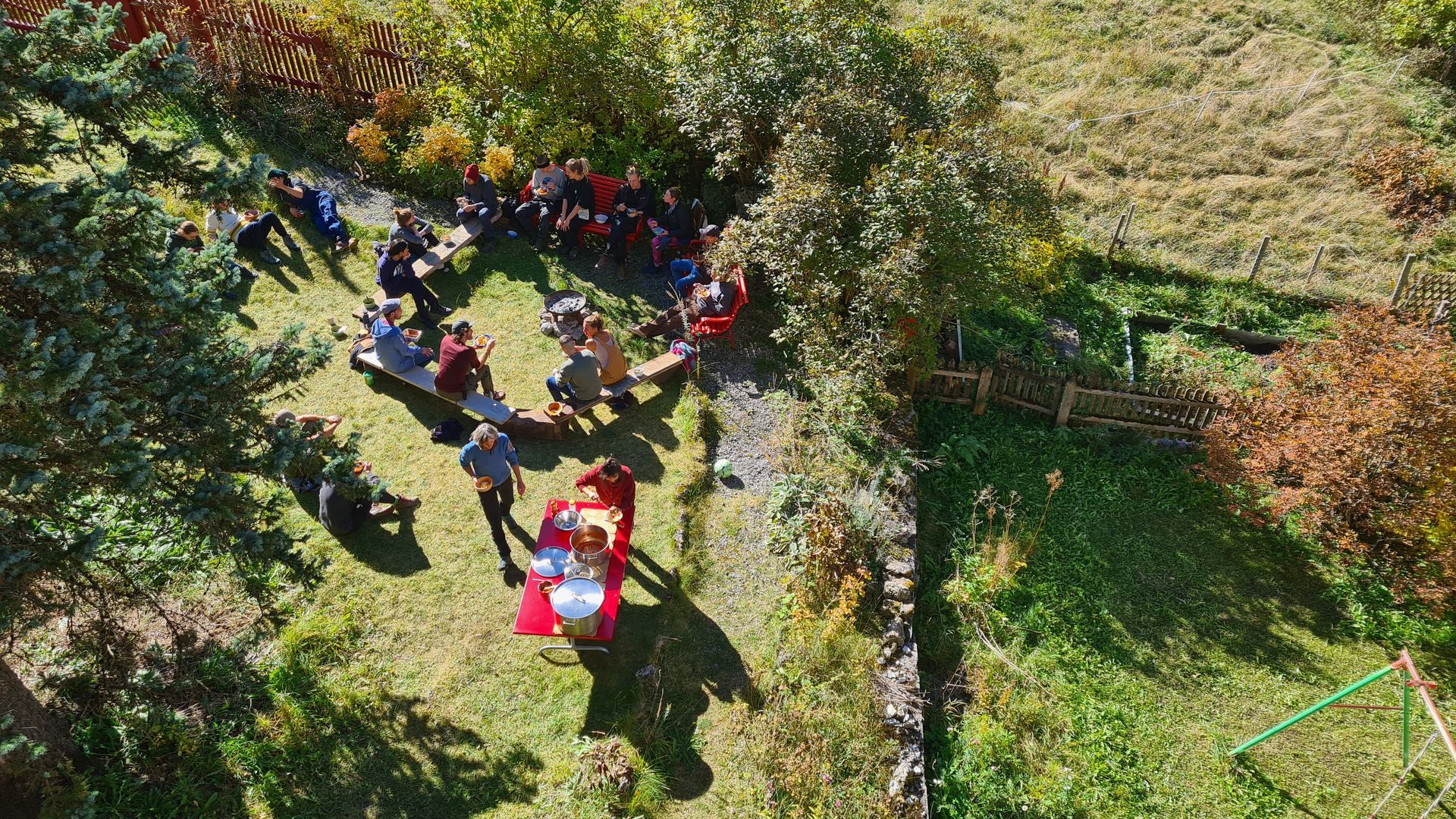 Eine Menschengruppe in einem Garten bei Sonnenschein, von oben fotografiert