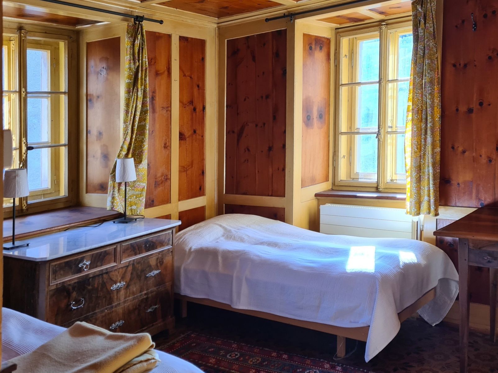 Ein helles Schlafzimmer mit zwei Fenstern und zwei Einzelbetten