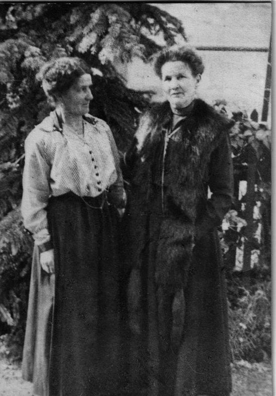 Zwei Damen in Kleidern um 1910, im Hintergrund ein Baum.