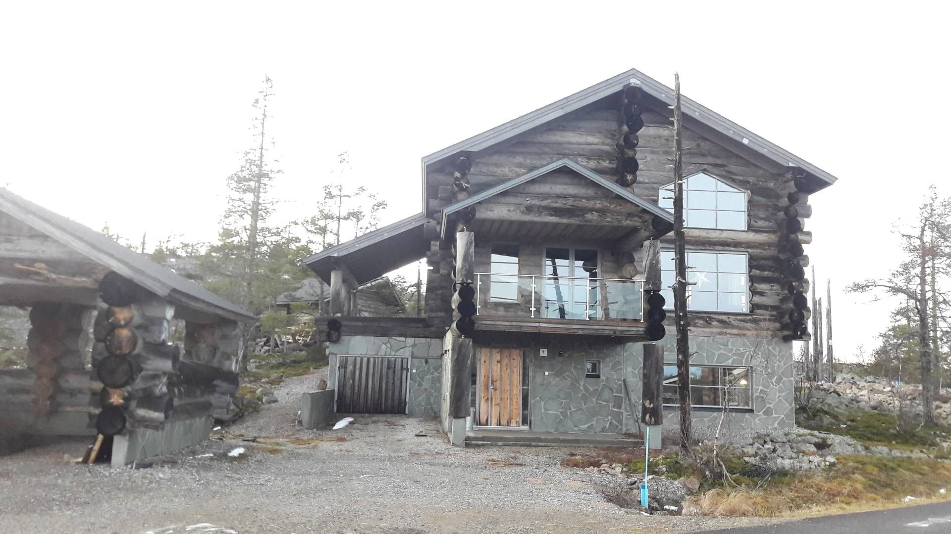 Näyttävän hirsihuvilan etupiha