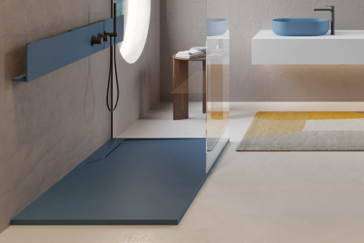 Zona de ducha azul con estante incorporado, contigua a un baño con lavabo blanco y alfombra colorida.