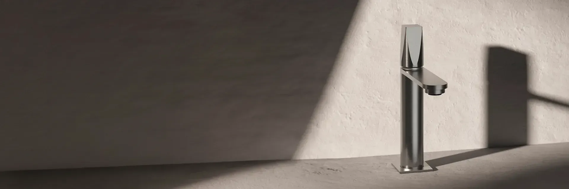 Un grifo cromado brillante contra una pared texturizada, con sombras proyectadas por la luz del sol.