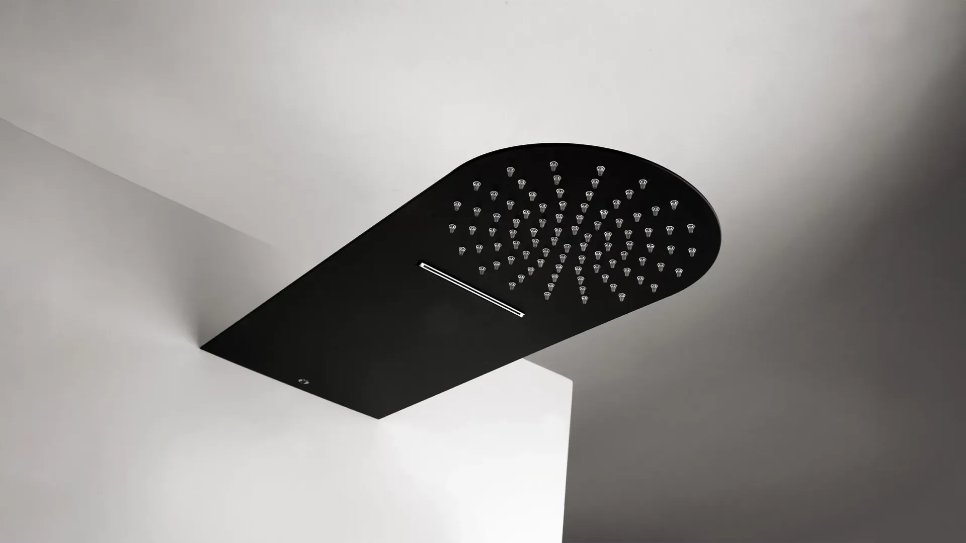 Cabezal de ducha negro de techo montado en una pared de esquina blanca.