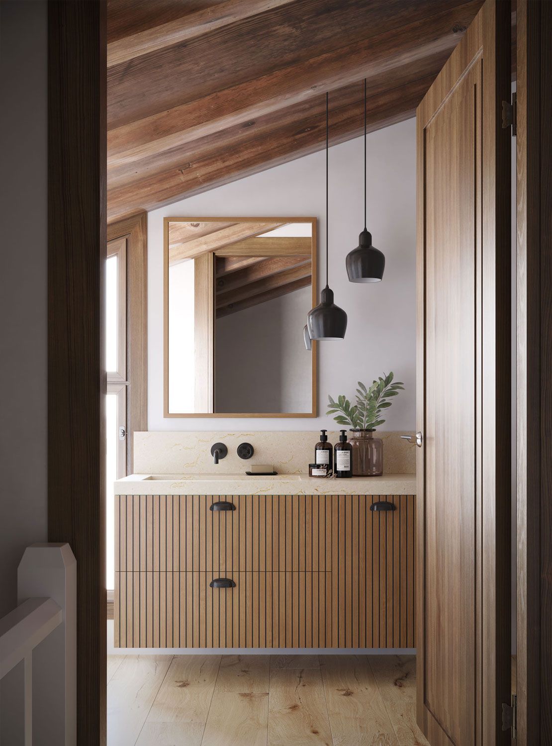 Baño con tocador de madera, espejo y lámparas colgantes; visto desde una puerta.