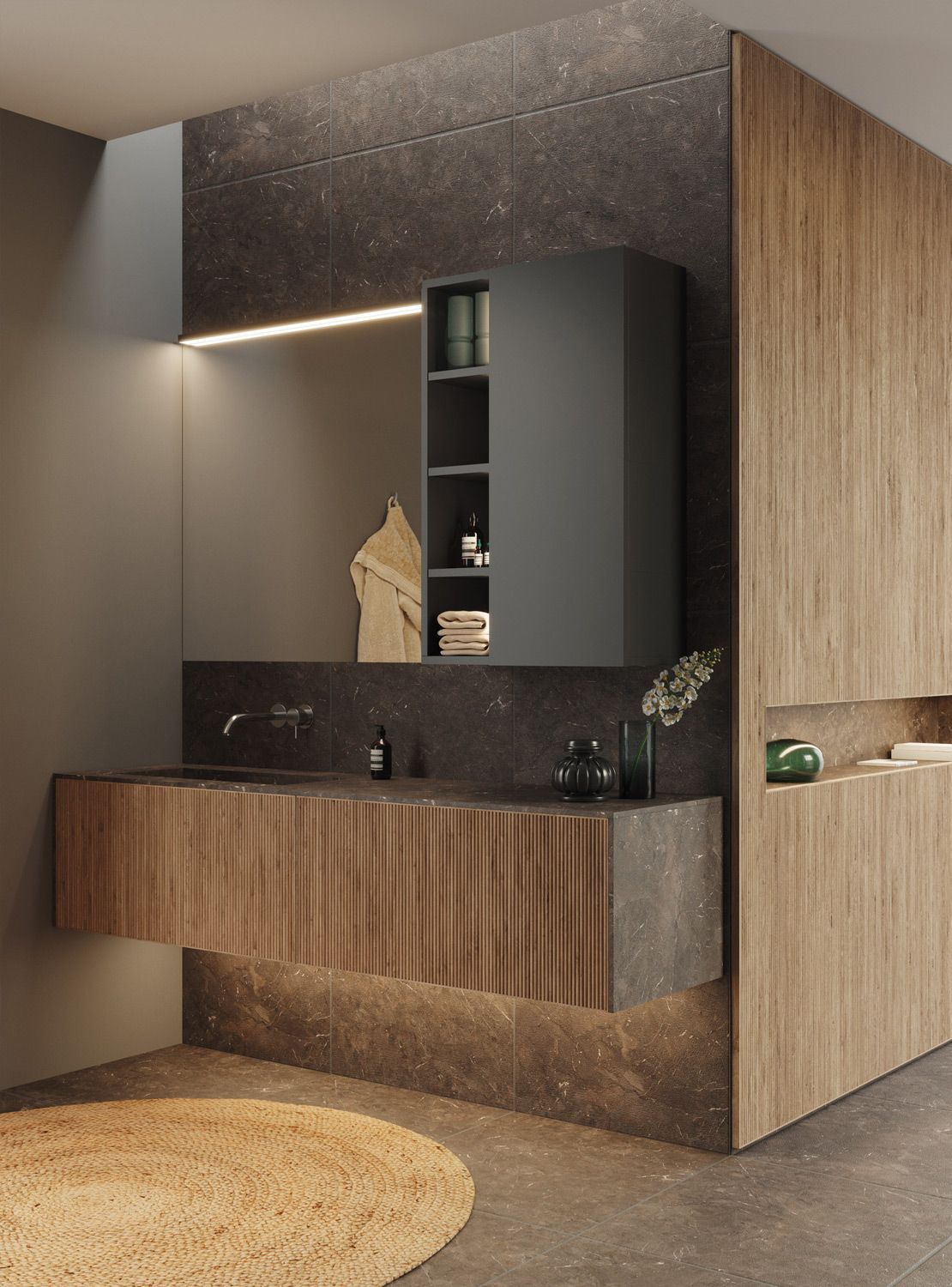 Baño moderno con tocador de madera, pared gris oscuro, espejo empotrado y alfombra circular.
