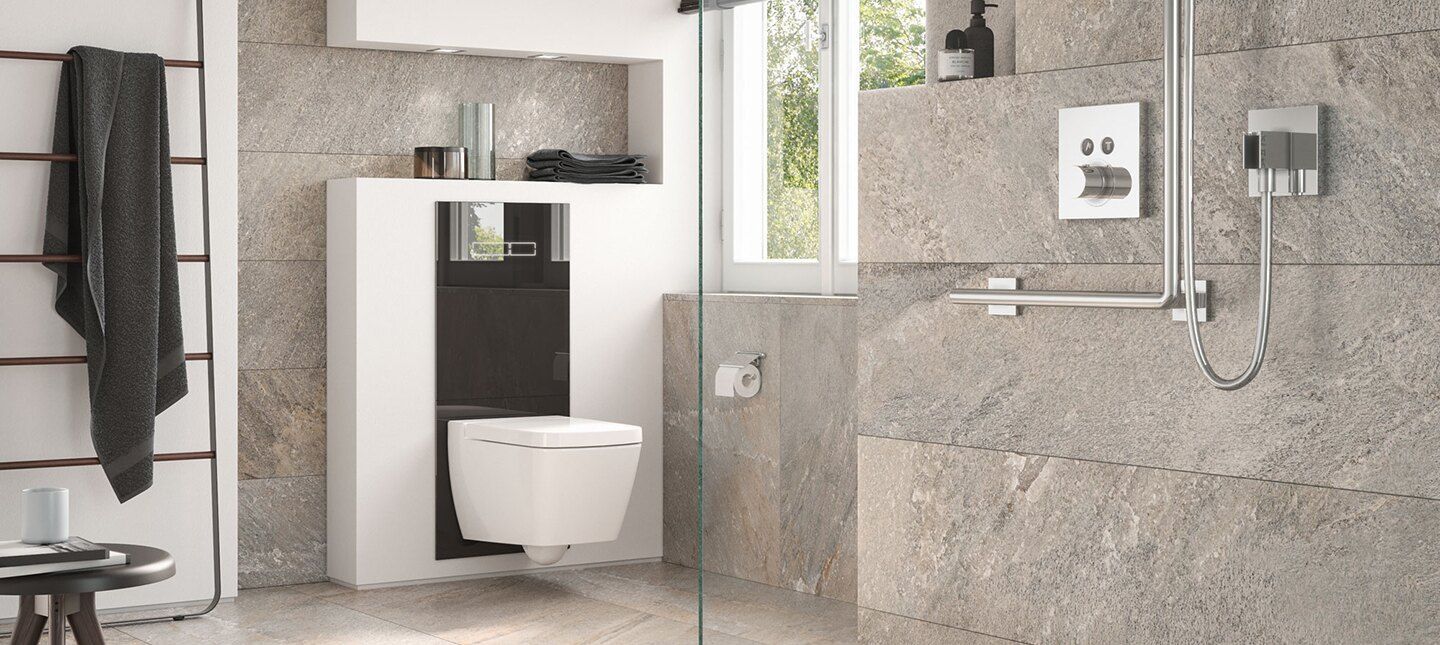 Baño moderno con inodoro suspendido, ducha y ventana con paredes texturizadas de piedra.