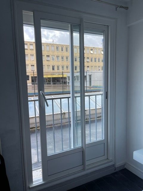 Porte-fenêtre en aluminium donnant sur un immeuble