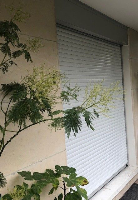 Fenêtre en gros plan avec volet roulant blanc baissé