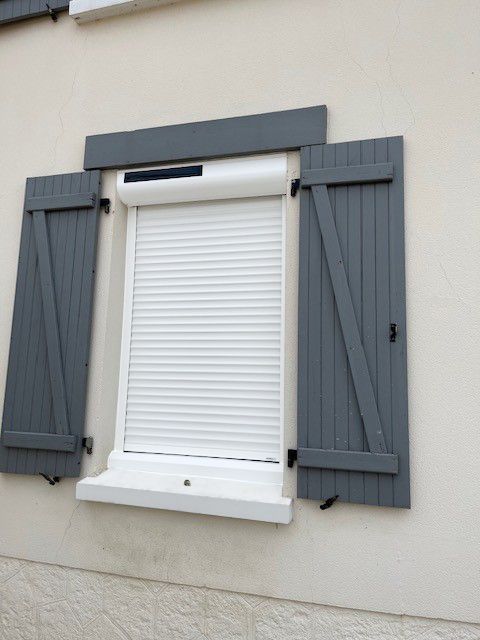 Fenêtre à volet solaire baissé et volets battants gris foncé