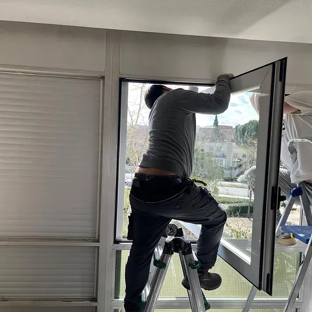 Una persona subida a una escalera instala 