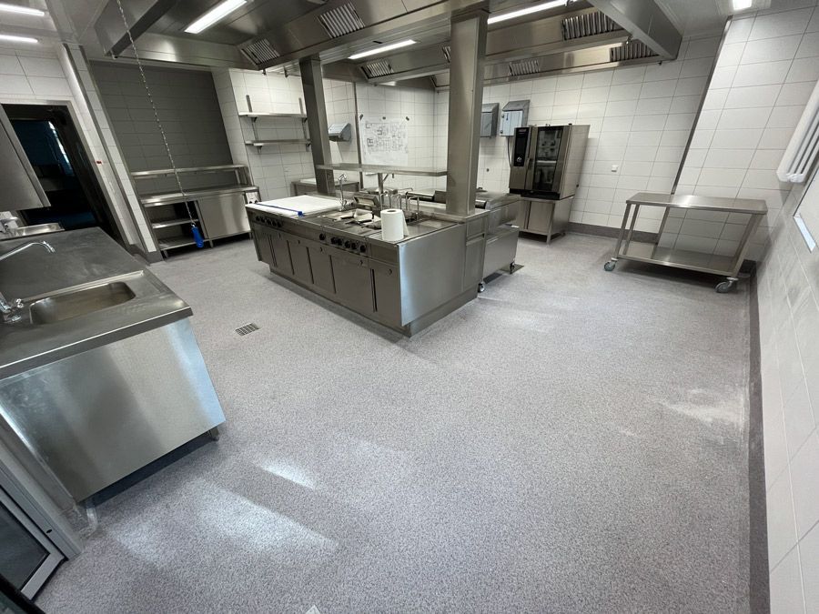 Eine lange Küche mit Schränken und Theken aus Edelstahl