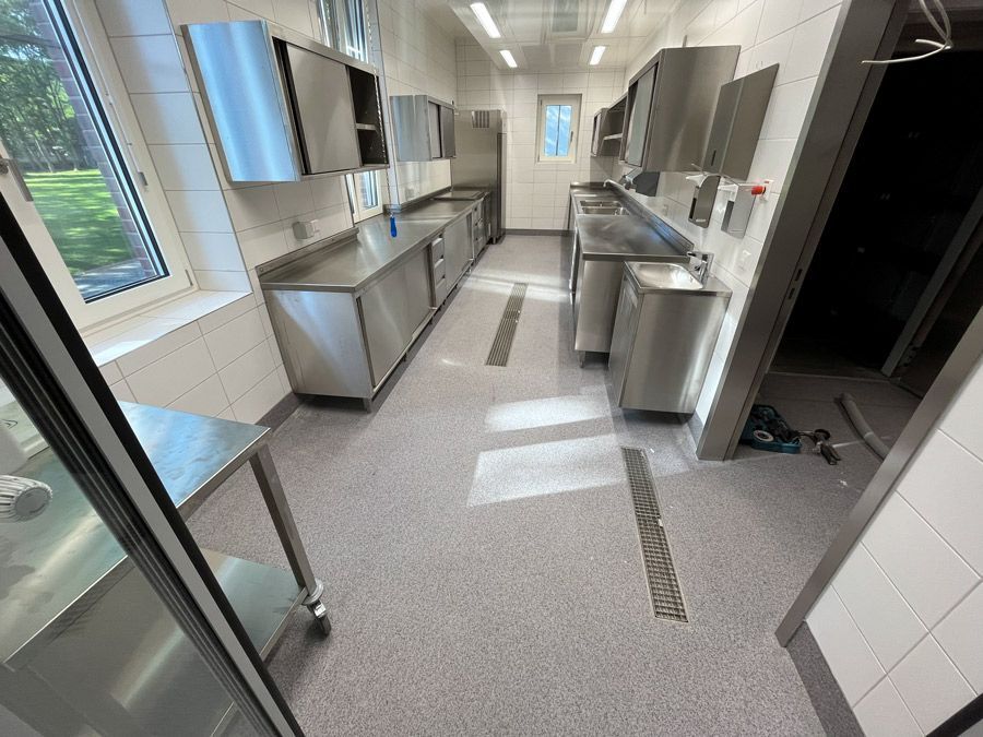 Eine lange Küche mit Schränken und Theken aus Edelstahl