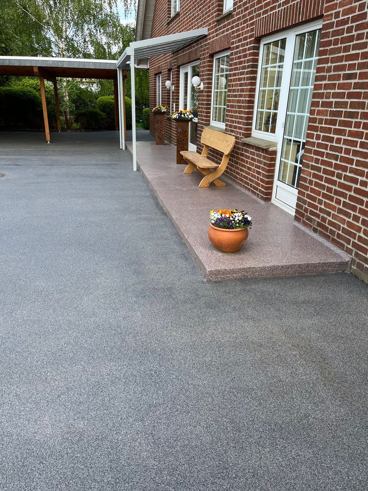 Ein Backsteingebäude mit einer Veranda und einer Bank davor.