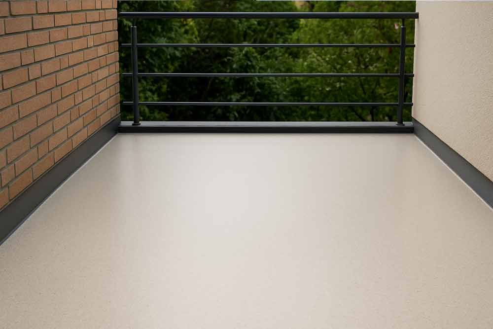 Ein leerer Balkon mit einer Ziegelmauer und einem Metallgeländer.