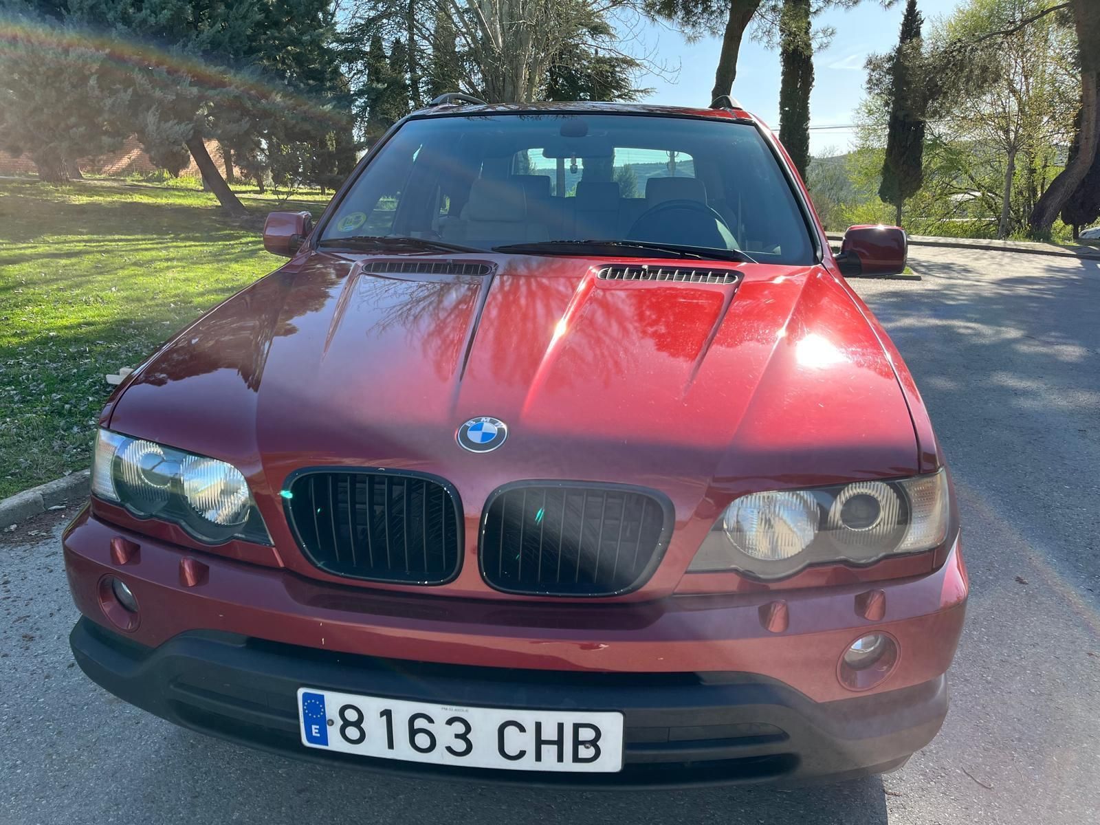 Un coche blanco con las puertas abiertas está estacionado al costado de la carretera.