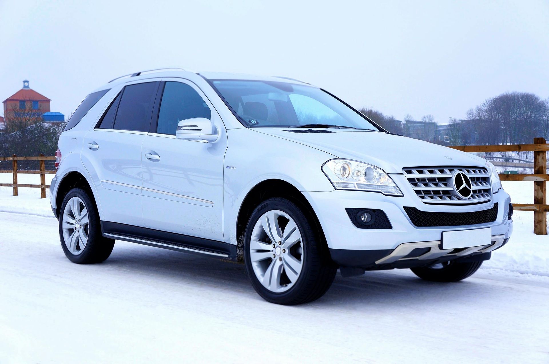 Un todoterreno Mercedes Benz de color blanco está estacionado en la nieve.
