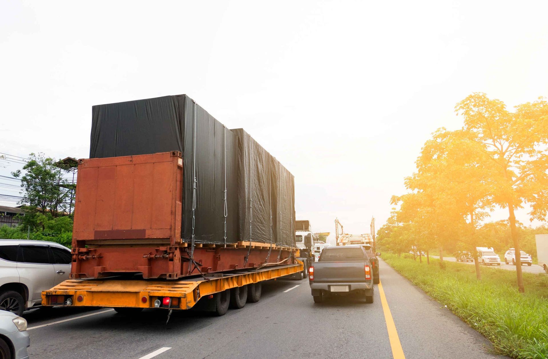 Un camión circula por una autopista con un remolque que transporta un contenedor de grandes dimensiones.