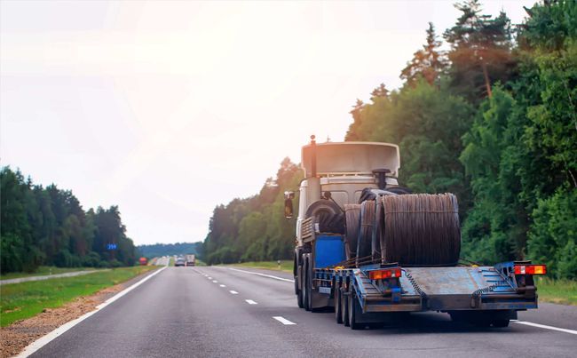Un camión semirremolque circula por una autopista con un remolque acoplado a él.