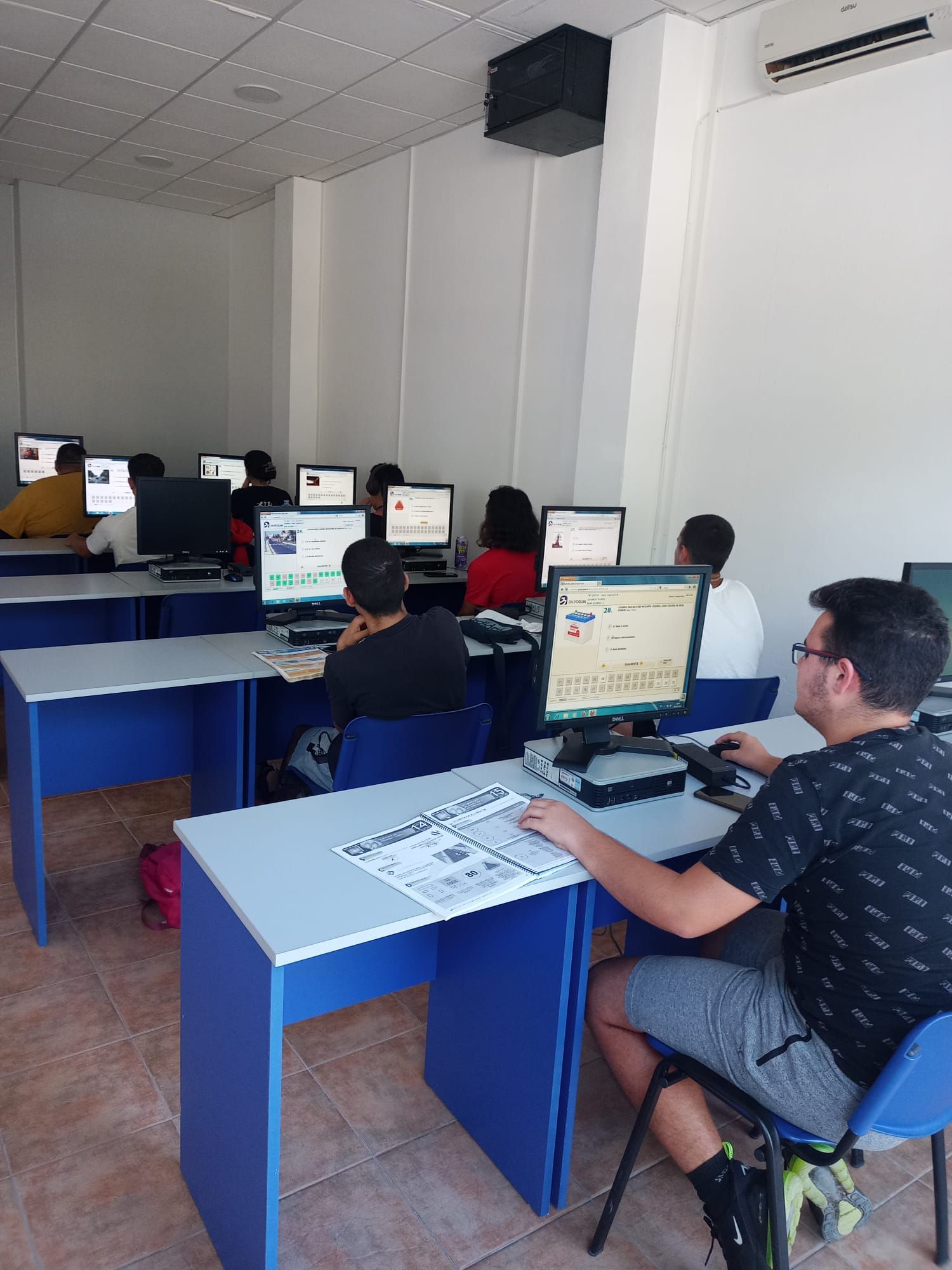 Un hombre está sentado en un escritorio frente a una computadora.