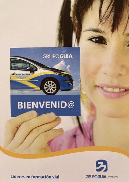 Una mujer sostiene una tarjeta de bienvenida frente a su cara.