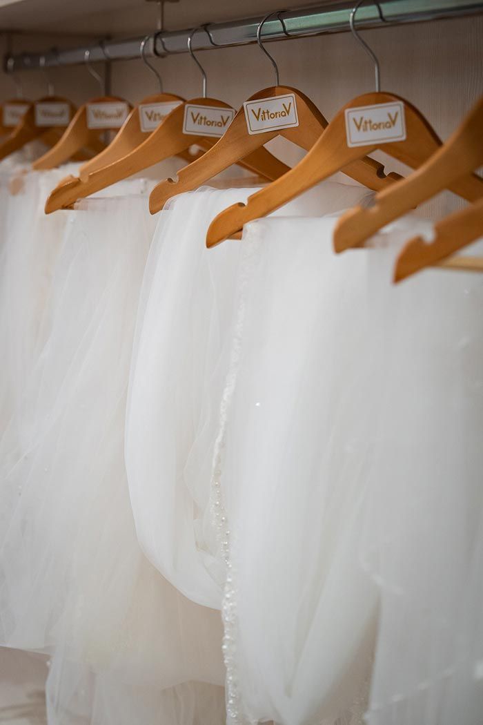 Faldas de tul blanco colgadas en perchas de madera, etiquetadas como