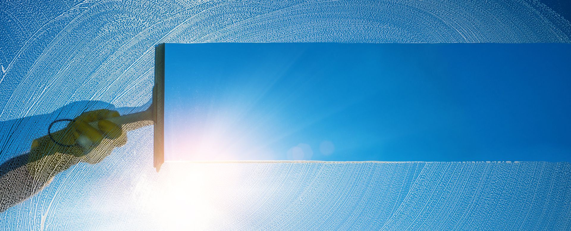 Ein weisser Lieferwagen parkt vor einem im Bau befindlichen Gebäude, ein Gerüst umgibt das Bauwerk, darüber blauer Himmel.