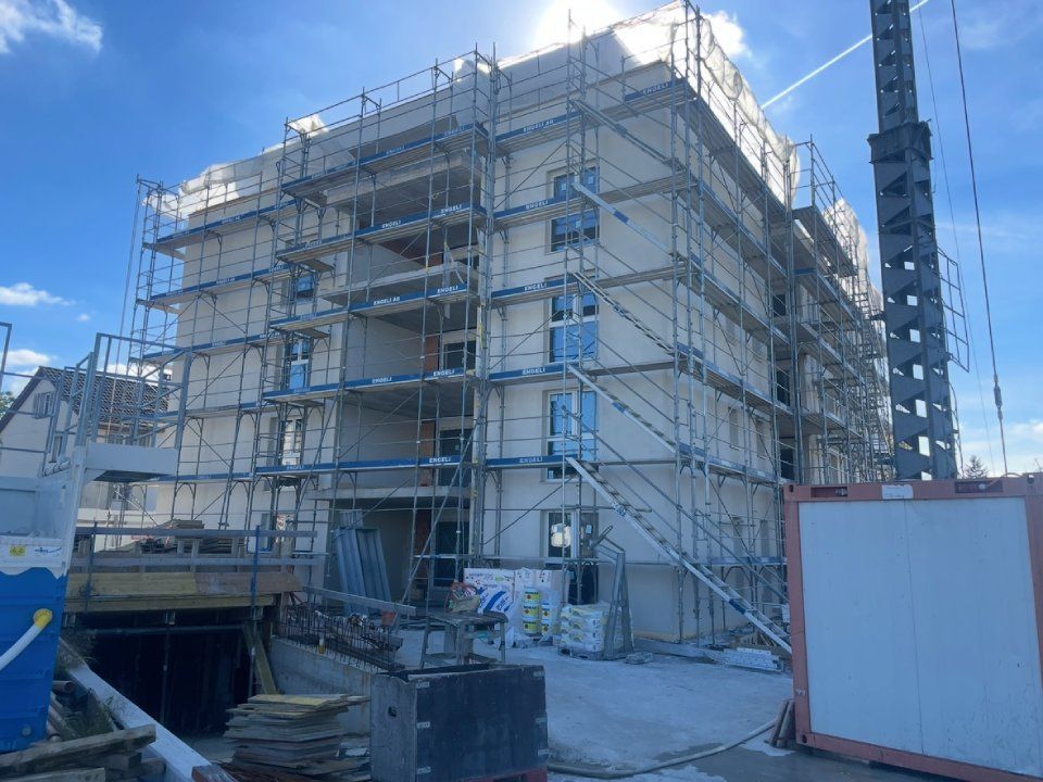 Gebäude im Bau, Gerüst, Kran, blauer Himmel.