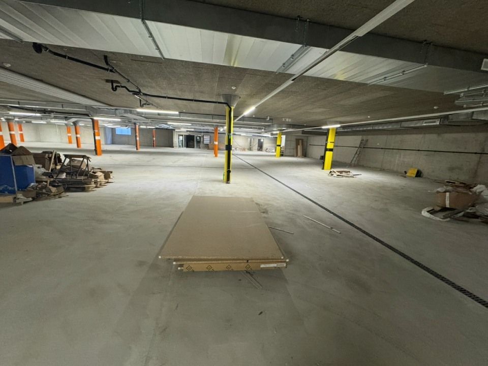 Eine leere, unfertige Parkgarage mit Betonwänden und Stützbalken.