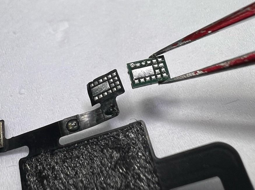 Se utilizan pinzas para retirar una pieza de equipo electrónico.