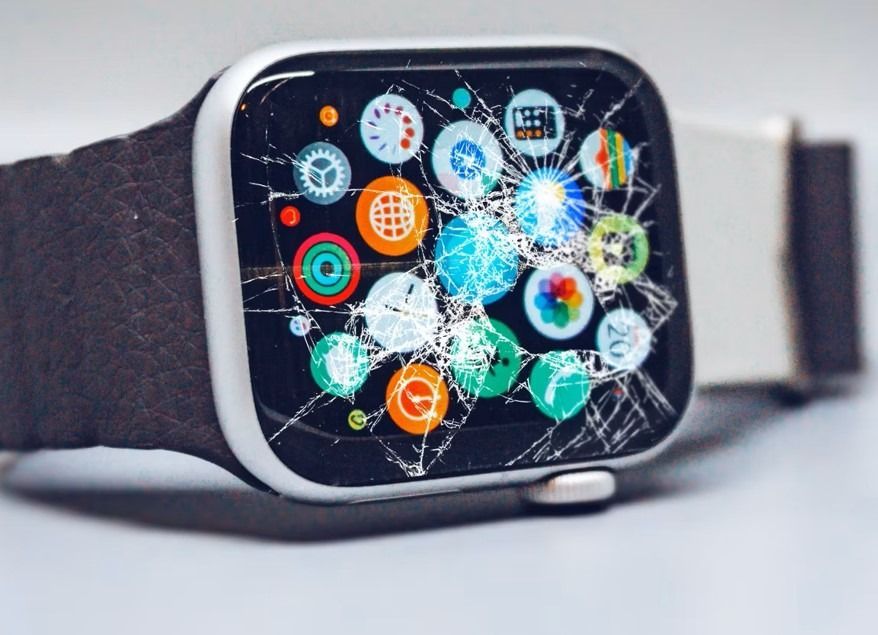 Un reloj de Apple con la pantalla rota está sobre una mesa.