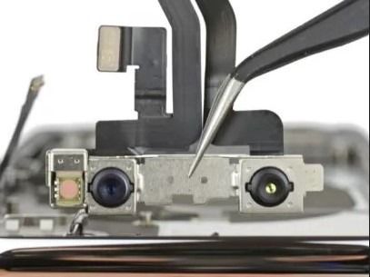 Un primer plano de un teléfono celular siendo reparado con pinzas.